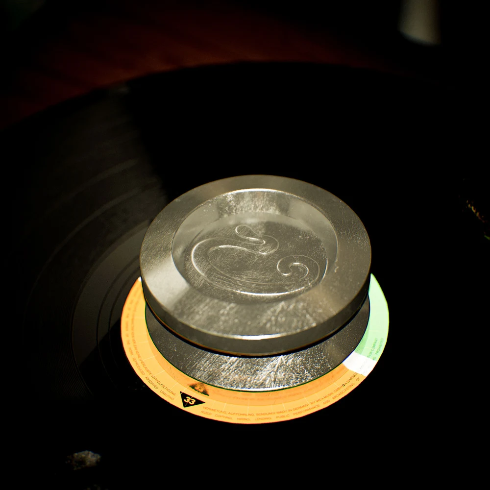 Silver-toned record stabilizer at the centre of a vinyl record
