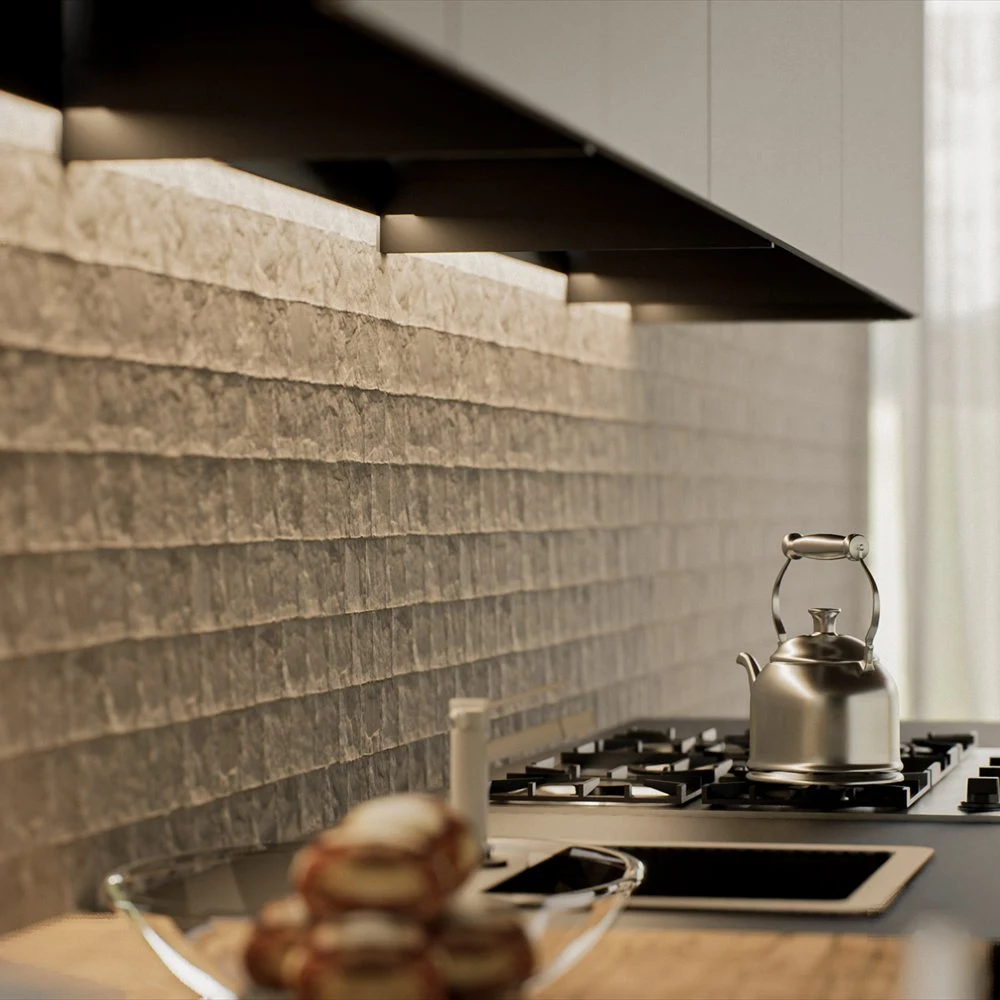 Kettle on a gas hob beside a rough-textured kitchen backsplash