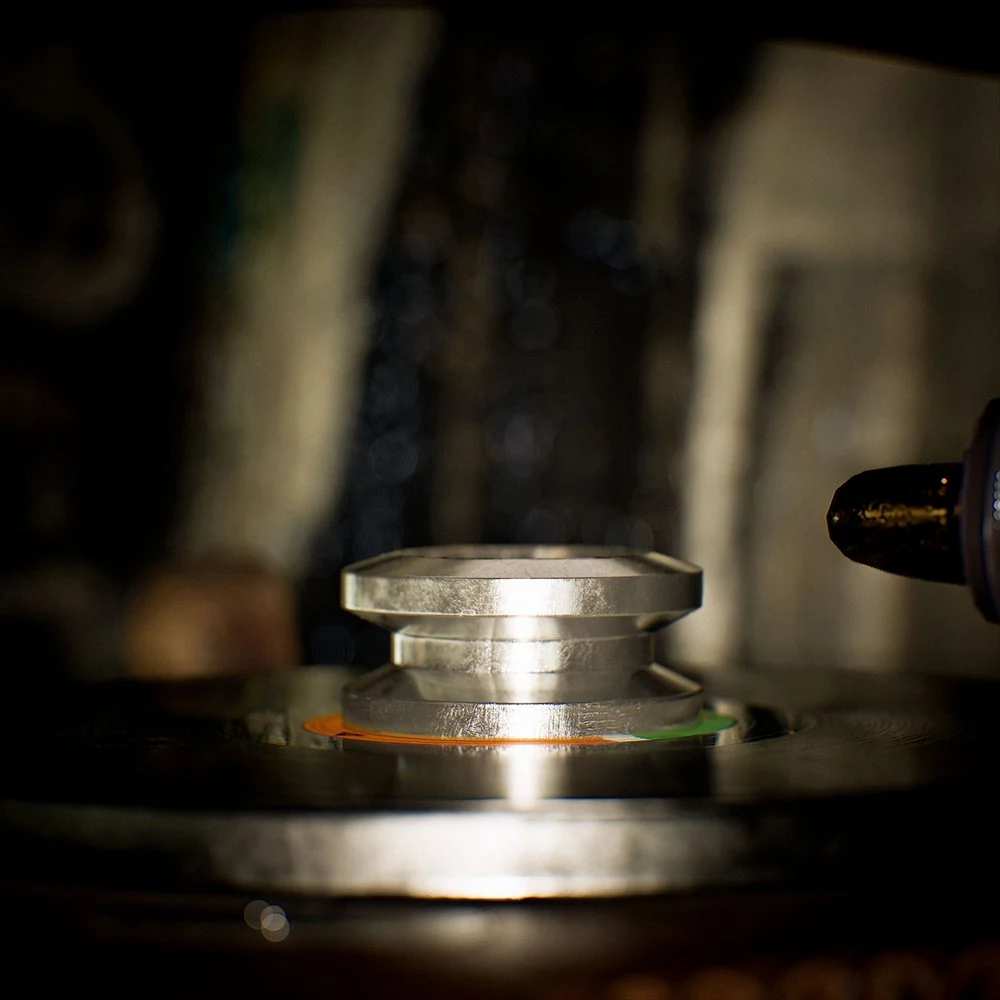 Side view of the stepped edge of a silver-toned record stabilizer