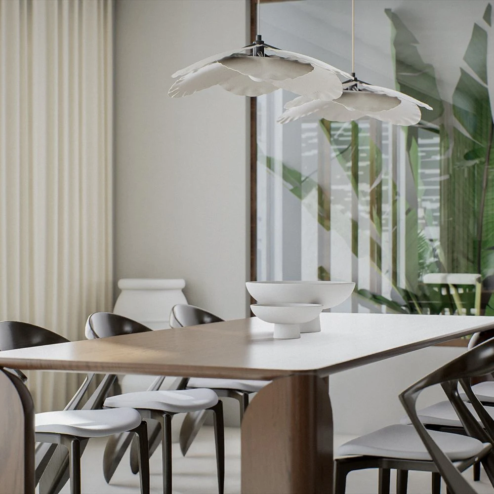 Dining table and dark chairs beneath a pendant beside leafy artwork
