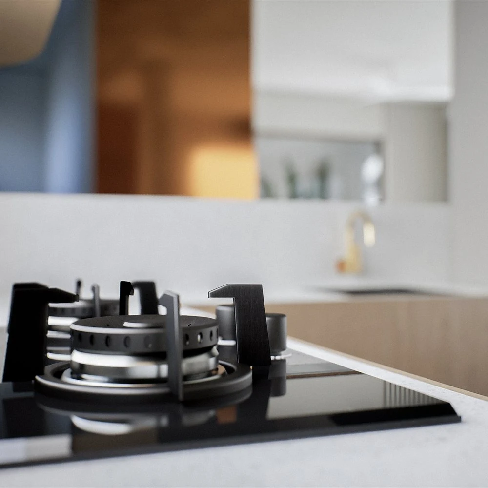 Black gas hob beside pale kitchen counters and wood-toned cabinetry
